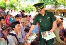 Cán bộ Đồn Biên phòng Mỹ Lý, BĐBP Nghệ An phát tờ rơi tuyên truyền phòng, chống mua bán người cho người dân trên địa bàn. Ảnh: Hải Thượng